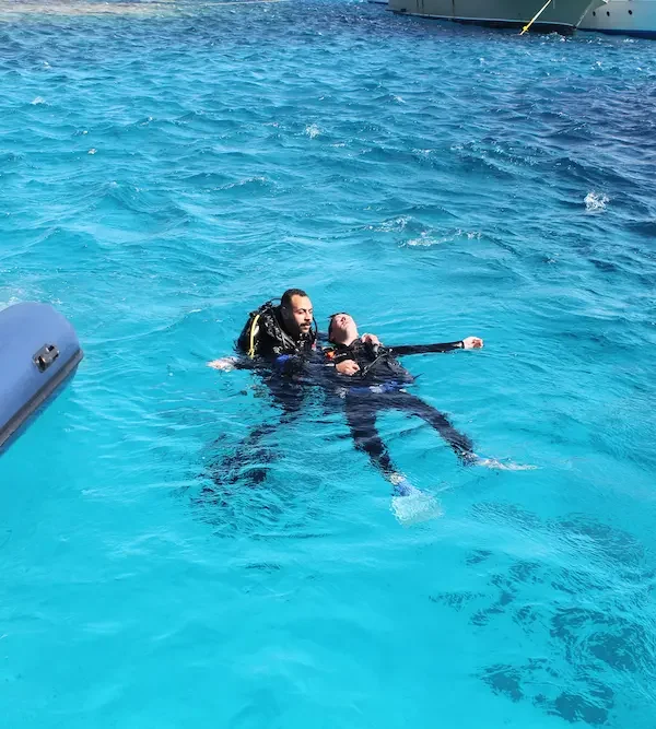 PADI Rescue Diver Course in Hurghada: Diving Mentor students practicing emergency diver stress management and unresponsive diver towing to a rescue boat in the Red Sea.